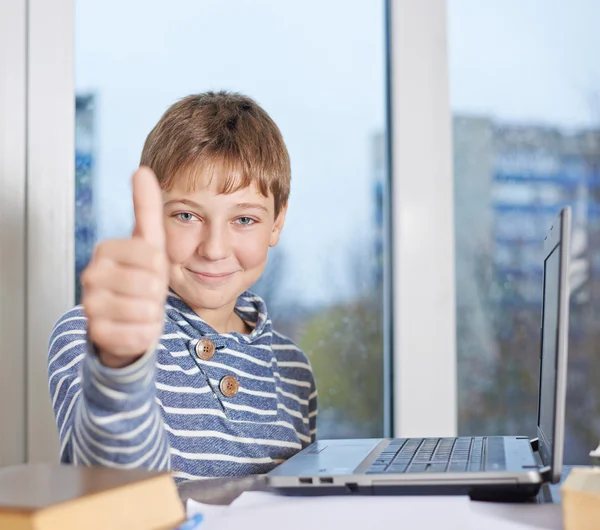 Boy  against the notebook showing  thumbs up