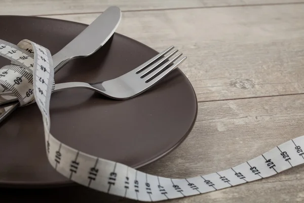 Plate with a knife and fork, measuring tape