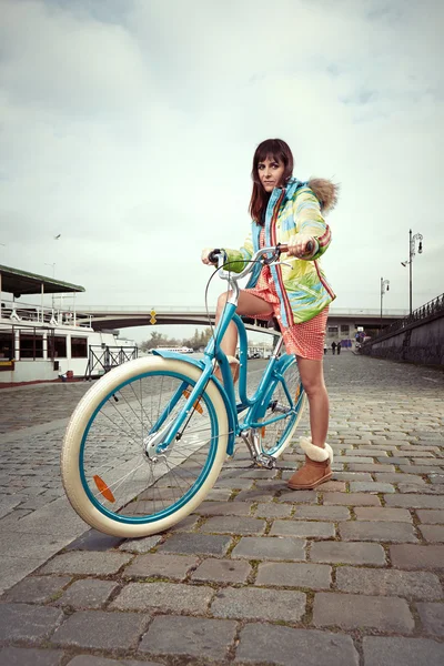 Nice girl on river bank with retro bike