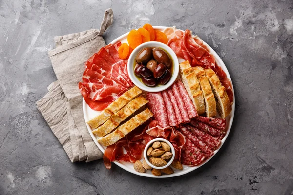 Cold meat plate with prosciutto, salami, ciabatta bread and olives