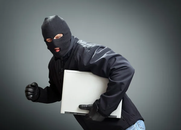 Thief stealing laptop computer