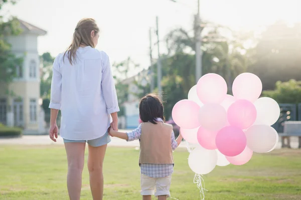 Asian mother and son holding hand together and walking