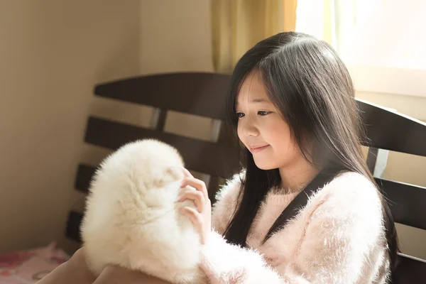 Little asian playing with siberian husky puppies