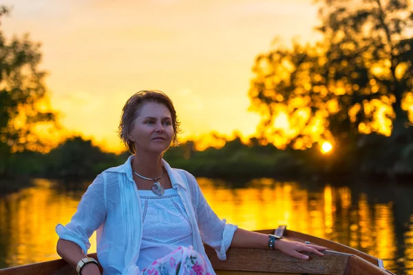 Woman  enjoying on boat at sunset on river
