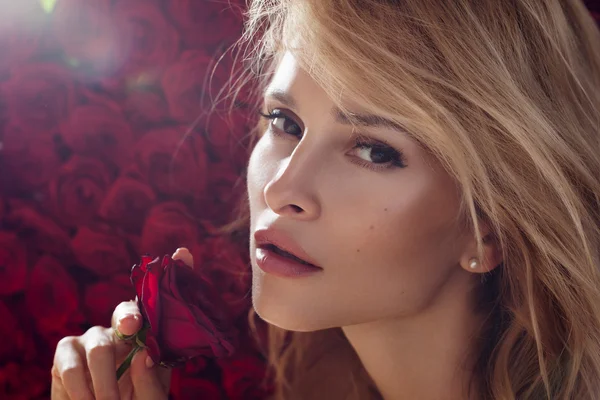 Fresh young fashion model with red lips. Wedding make up. Roses. Flowers background.