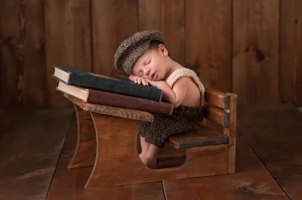 Newborn Baby Boy Sleeping at his School Desk