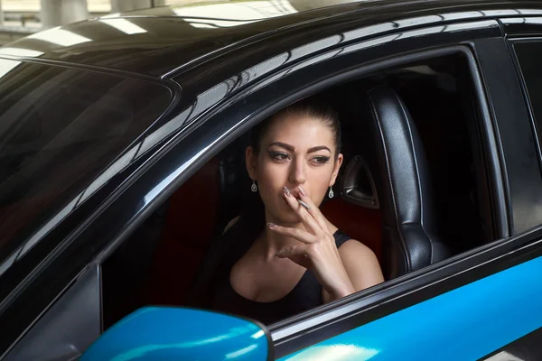 Woman smokes in the car