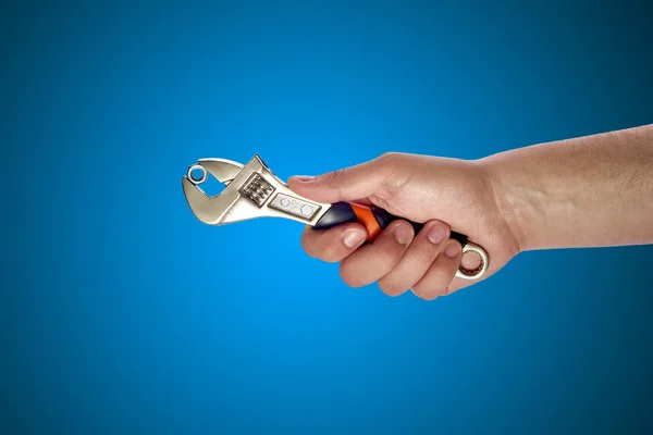 Man's hand holding big wrench