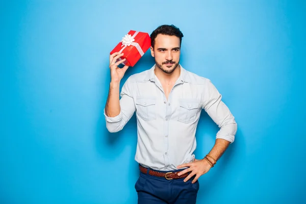 Handsome adult man on blue background with christmas gift