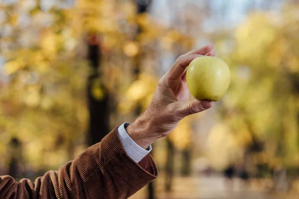 Senior adult holding green apple