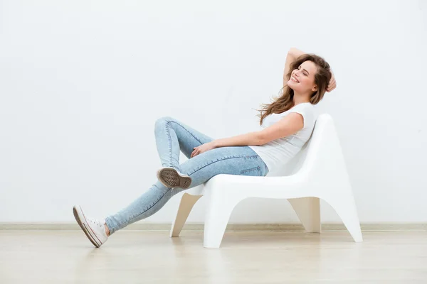 Single woman sitting on white chair