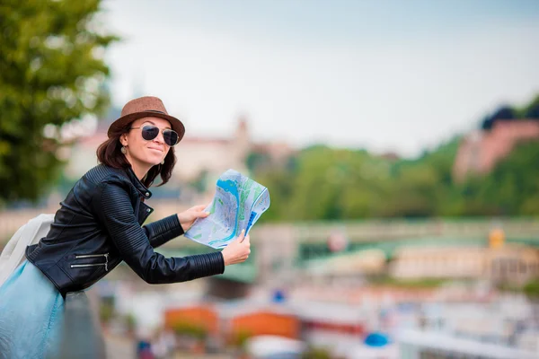 Happy young woman with a city map in Europe. Travel tourist woman with map in Prague outdoors during holidays in Europe.