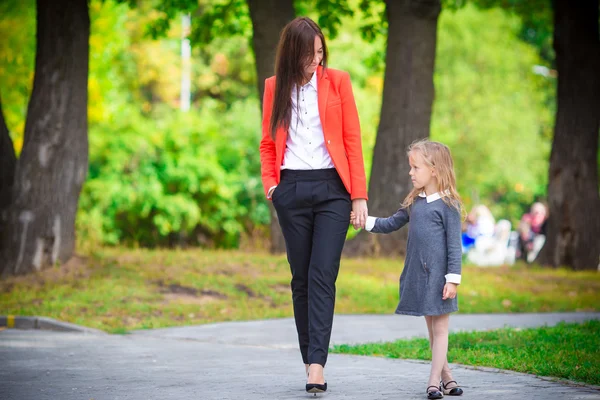 Mother brings her daughter to school. Adorable little girl feeling very excited about going back to school