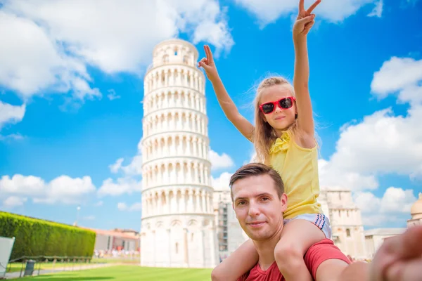 Family portrait background the Learning Tower in Pisa. Pisa - travel to famous places in Europe.