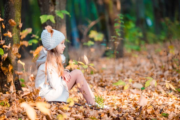 Little girl in autumn park outdoors