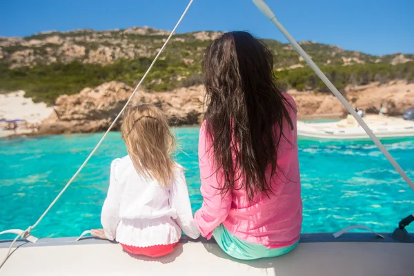 Young mother with her adorable daughter resting on a big boat