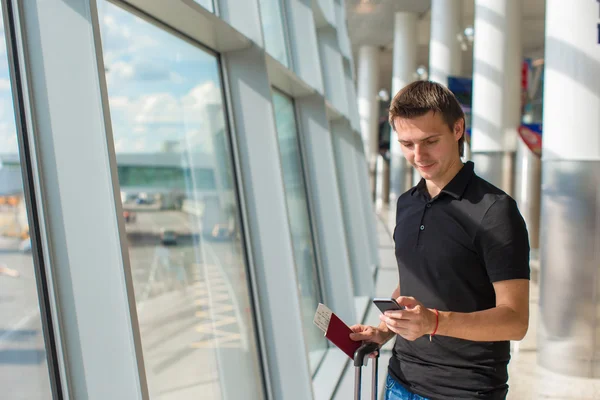 Young man talking on phone inside the airport