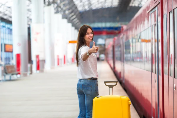 Young caucasian woman with luggage at station traveling by train