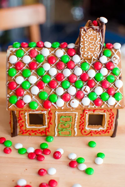 Gingerbread fairy house on a background of bright Christmas tree with garland