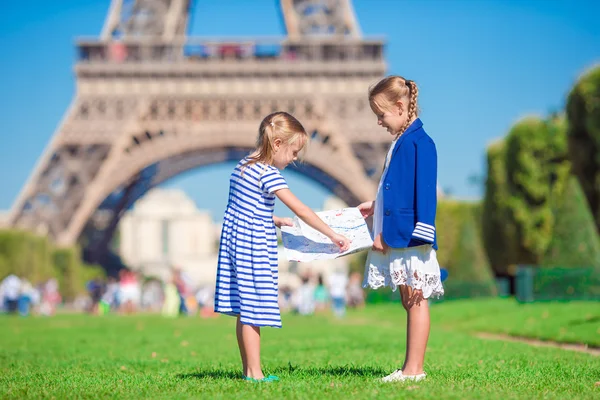 Adorable little girls with map of Paris background the Eiffel tower