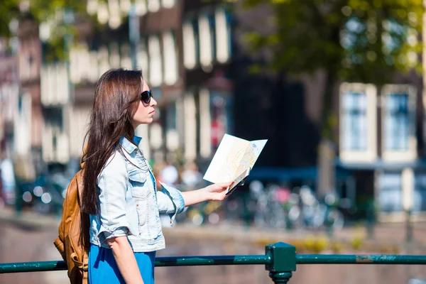 Young woman with city map in european city at Amsterdam