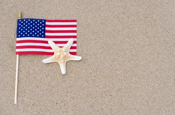 Amrican flag with starfish on the sandy beach