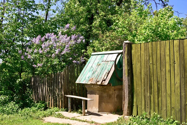 The wooden fence and a well in the village