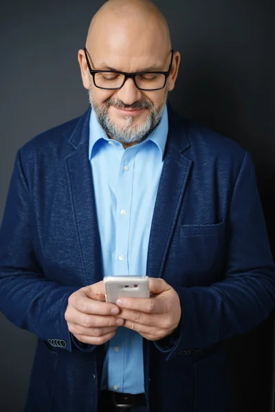 Man Wearing Eyeglasses Smiling Down at Cell Phone