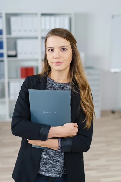 Executive holding folders in small office
