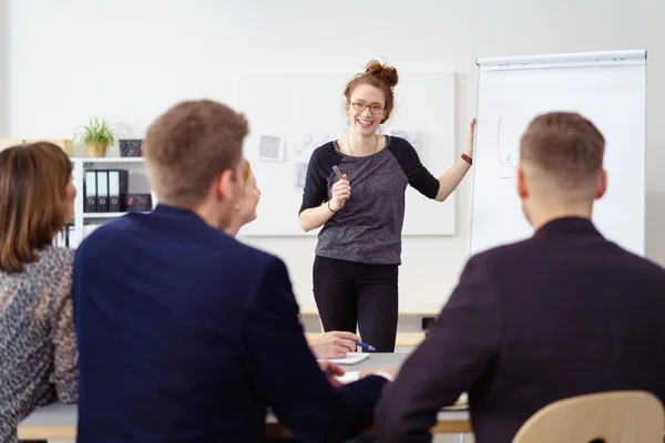 Cheerful woman at chart during staff meeting