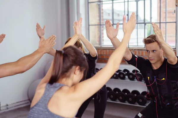 Group exercising by tall windows in fitness studio