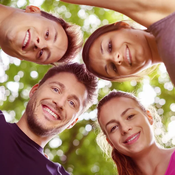 Group of four young friends looking downward