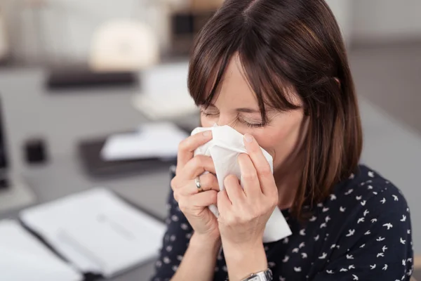Sick Lady Sneezing Into a Tissue