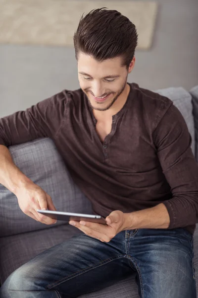 Happy Young Guy with Tablet Relaxing on the Couch