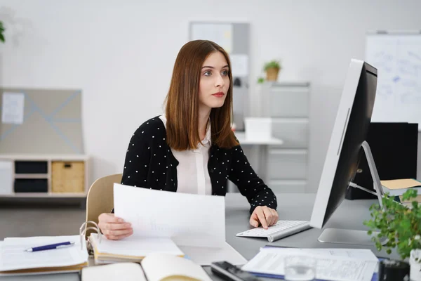 Businesswoman reading a desktop monitor