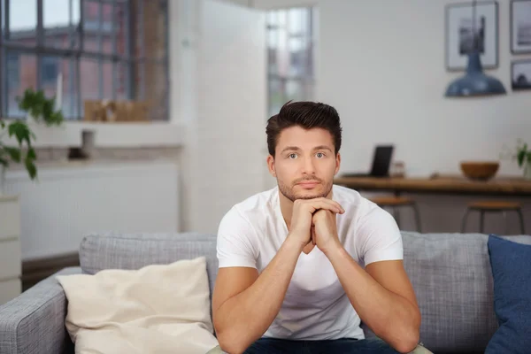 Relaxed young man leaning chin on hands