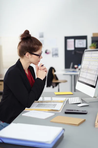 Businesswoman sitting reading her monitor