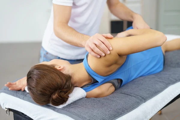 Male Osteopath Stretching the Body of his Patient