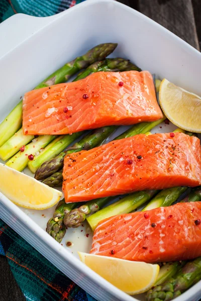 Fresh delicious salmon, green asparagus and lemon in pan