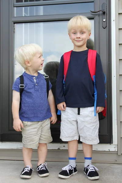 Little Child Looking Up to Big Brother on First Day of School
