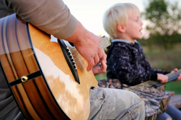 Father and Son Outside PLaying Guitar and Singing