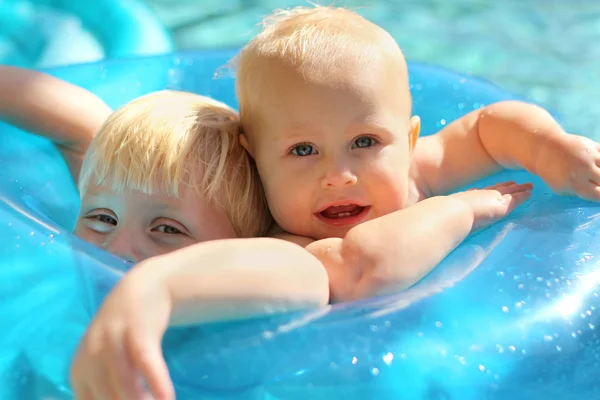 Baby and Big Brother Together in Raft in Swimming Pool