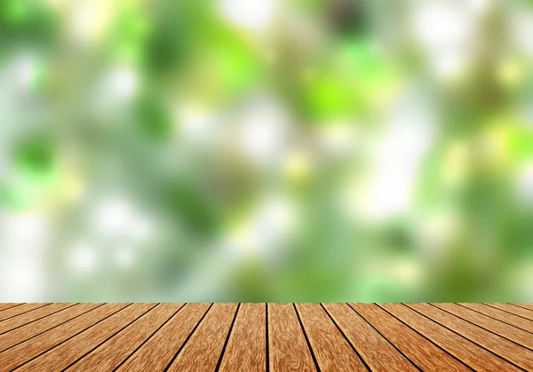 Wood table top with blur green nature bokeh background.can use for magazine or put any word on it