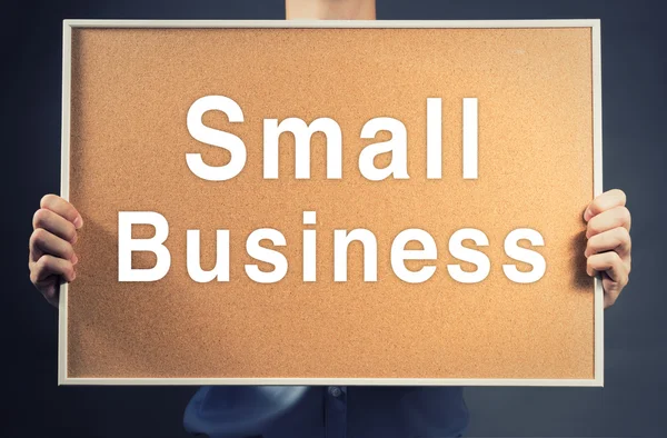 Businessman Holding blank wood Board SMALL BUSINESS Word