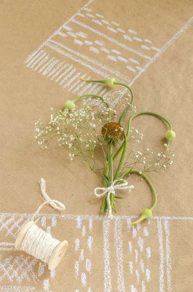 Still life with garlic, buds, flowers and spool of twine
