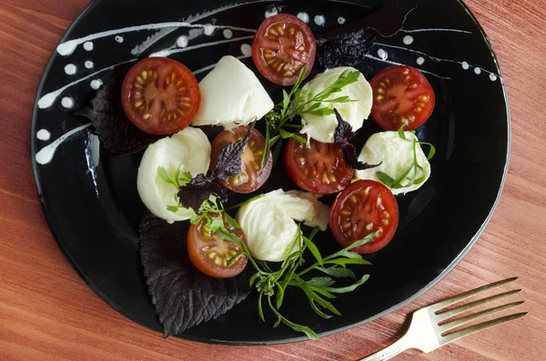 Ingradients for Italian caprese salad with fresh basil leaves, tomato and  mozzarella  on red wooden table