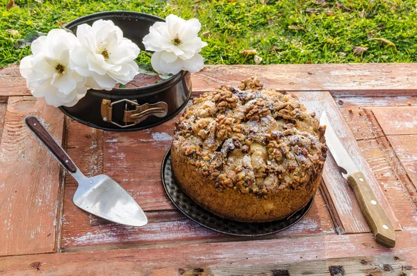 Autumn still life with cake, walnuts and white roses. Rustic style.