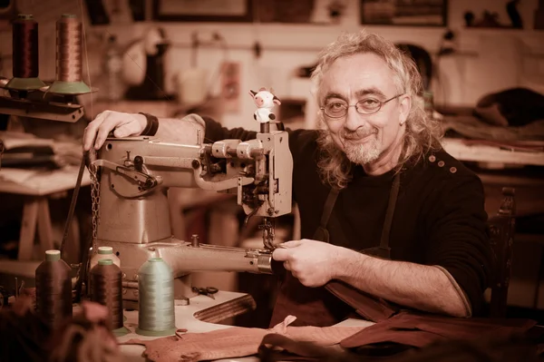 Leather goods craftsman at work in his workshop