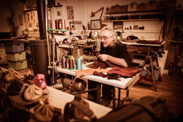 Leather goods craftsman at work in his workshop