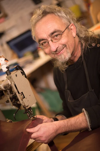 Leather goods craftsman at work in his workshop